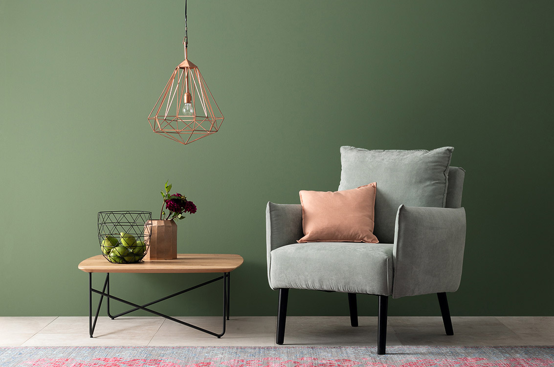 Wohnzimmer mit grünem Sessel, Designfarbe Piniengrün